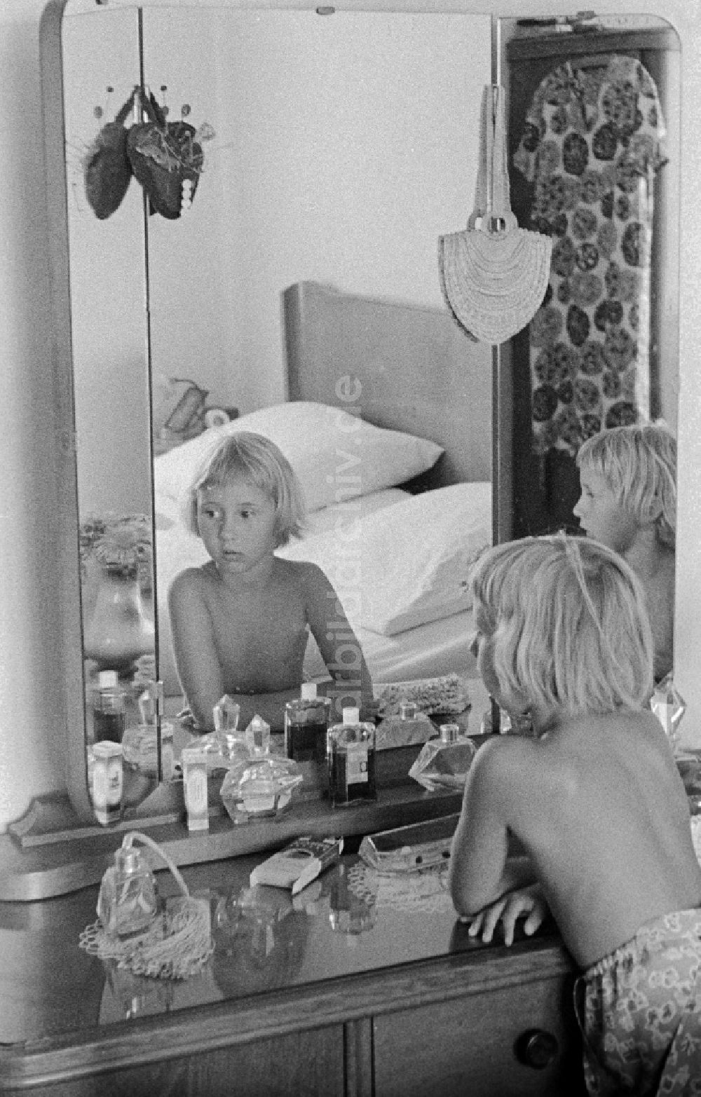 DDR-Bildarchiv: Halle (Saale) - Zwei Kinder vor einer Frisierkommode mit 3-teiligen Spiegel, Glasplatte und verschiedenen Flakons in Halle (Saale) in Sachsen-Anhalt in der DDR