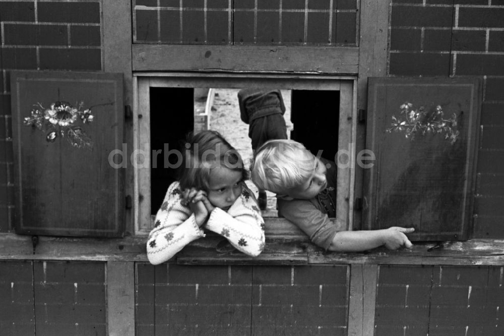 DDR-Fotoarchiv: Bad Dürrenberg - Zwei Kinder spielen in einem Spielhaus mit Fensterläden auf einem Spielplatz in Bad Dürrenberg in Sachsen-Anhalt in Deutschland
