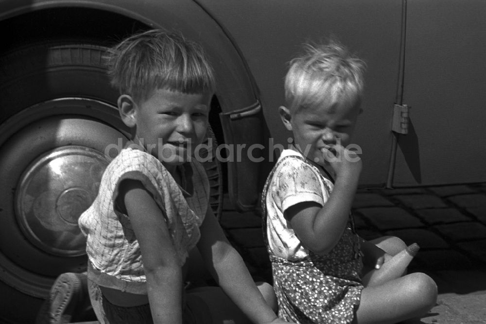 Magdeburg: Zwei kleine Jungen sitzen auf dem Bürgersteig vor einem VW Käfer in Magdeburg in Sachsen - Anhalt