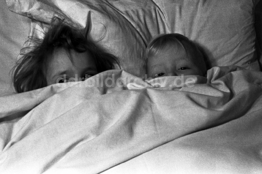 DDR-Fotoarchiv: Merseburg - Zwei kleine Kinder liegen lachend im Bett der Eltern in Merseburg im Bundesland Sachsen-Anhalt in Deutschland