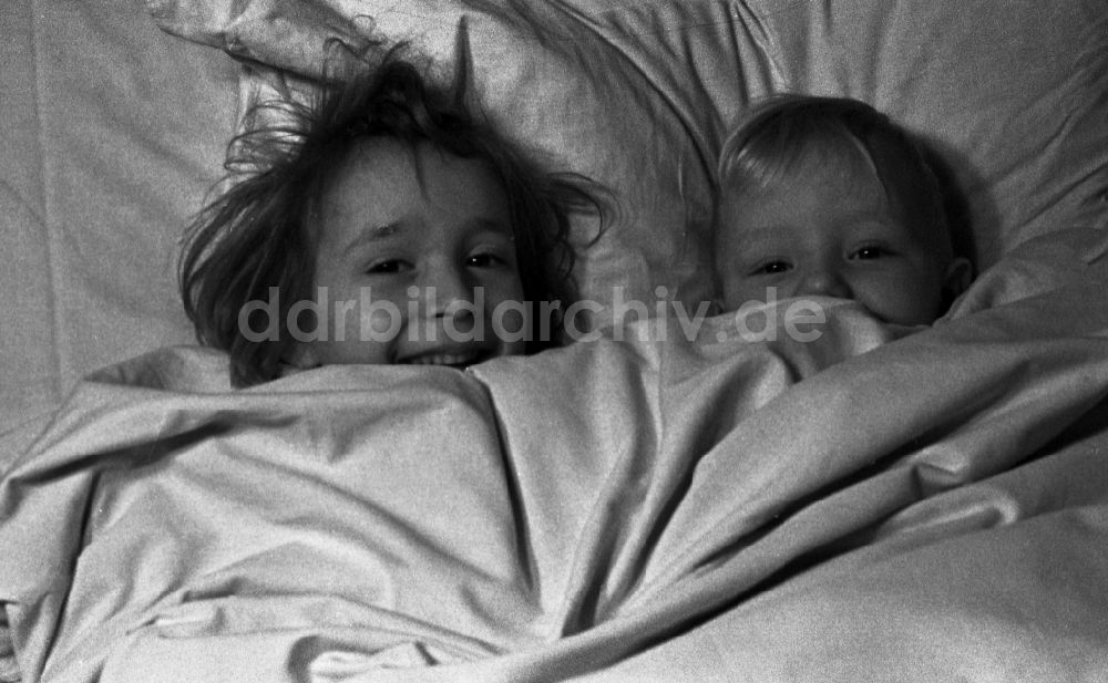 Merseburg: Zwei kleine Kinder liegen lachend im Bett der Eltern in Merseburg im Bundesland Sachsen-Anhalt in Deutschland