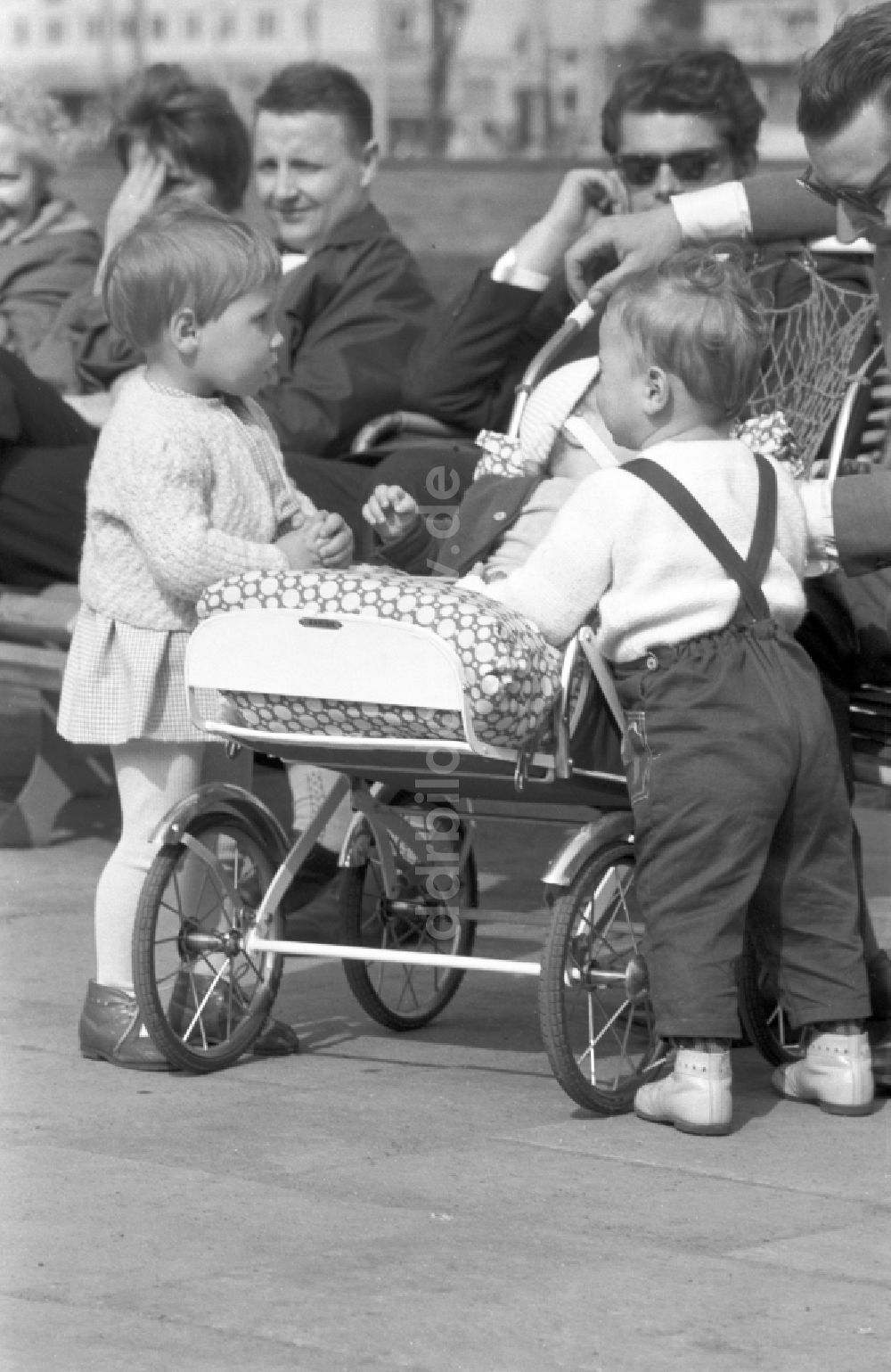 Dessau: Zwei kleine Kinder stehen neugierig an einem Kinderwagen in Dessau 