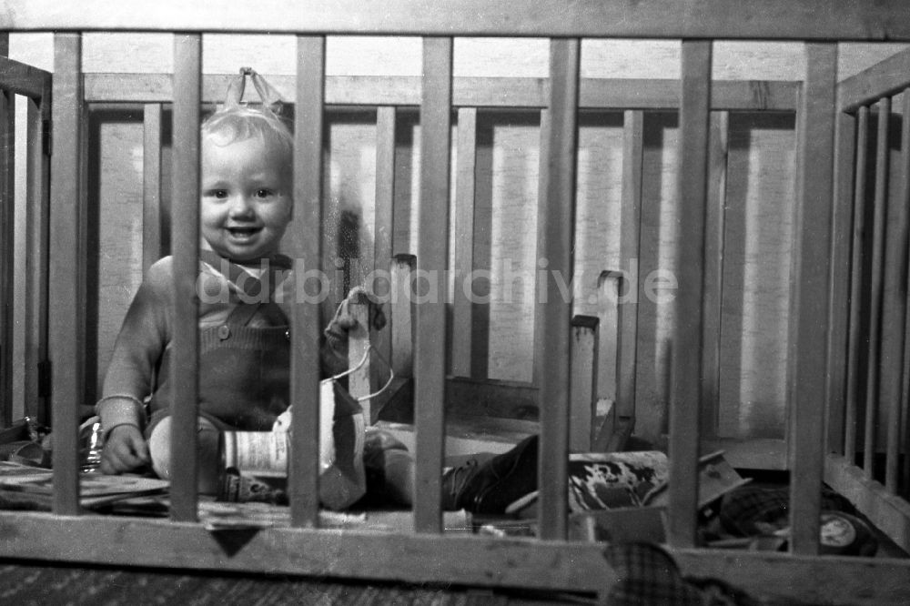 DDR-Fotoarchiv: Merseburg - Zwei spielende Kinder in einem Laufstall - Laufgitter in Merseburg in Sachsen-Anhalt in Deutschland